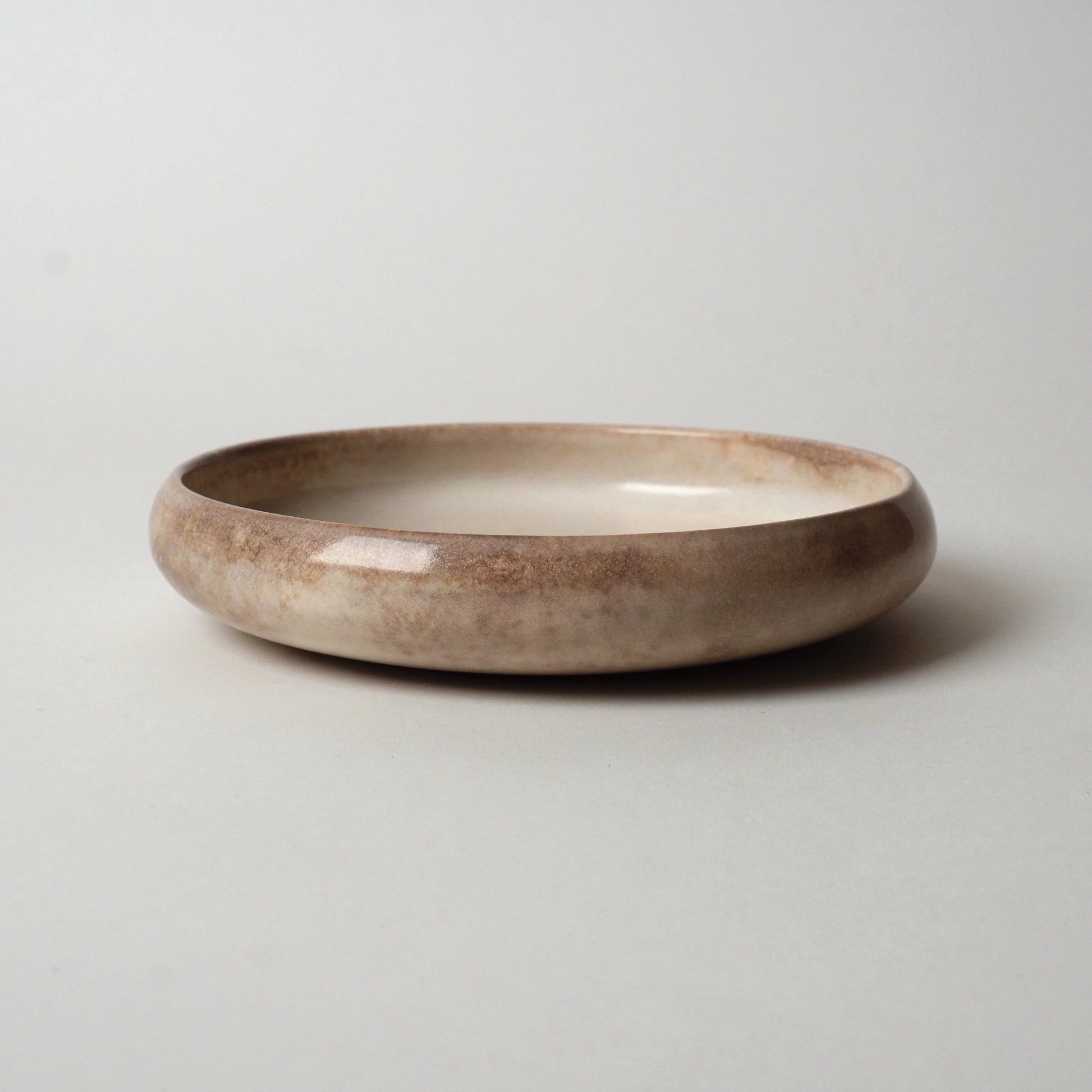 Ceramic bowl with a brownish hue on a light gray background