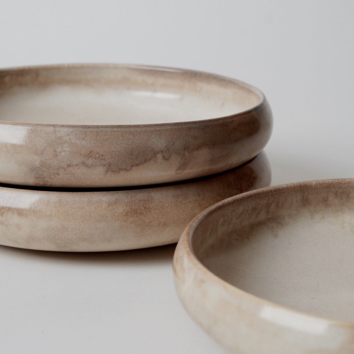 Three ceramic bowls with a earthy tone on a light background
