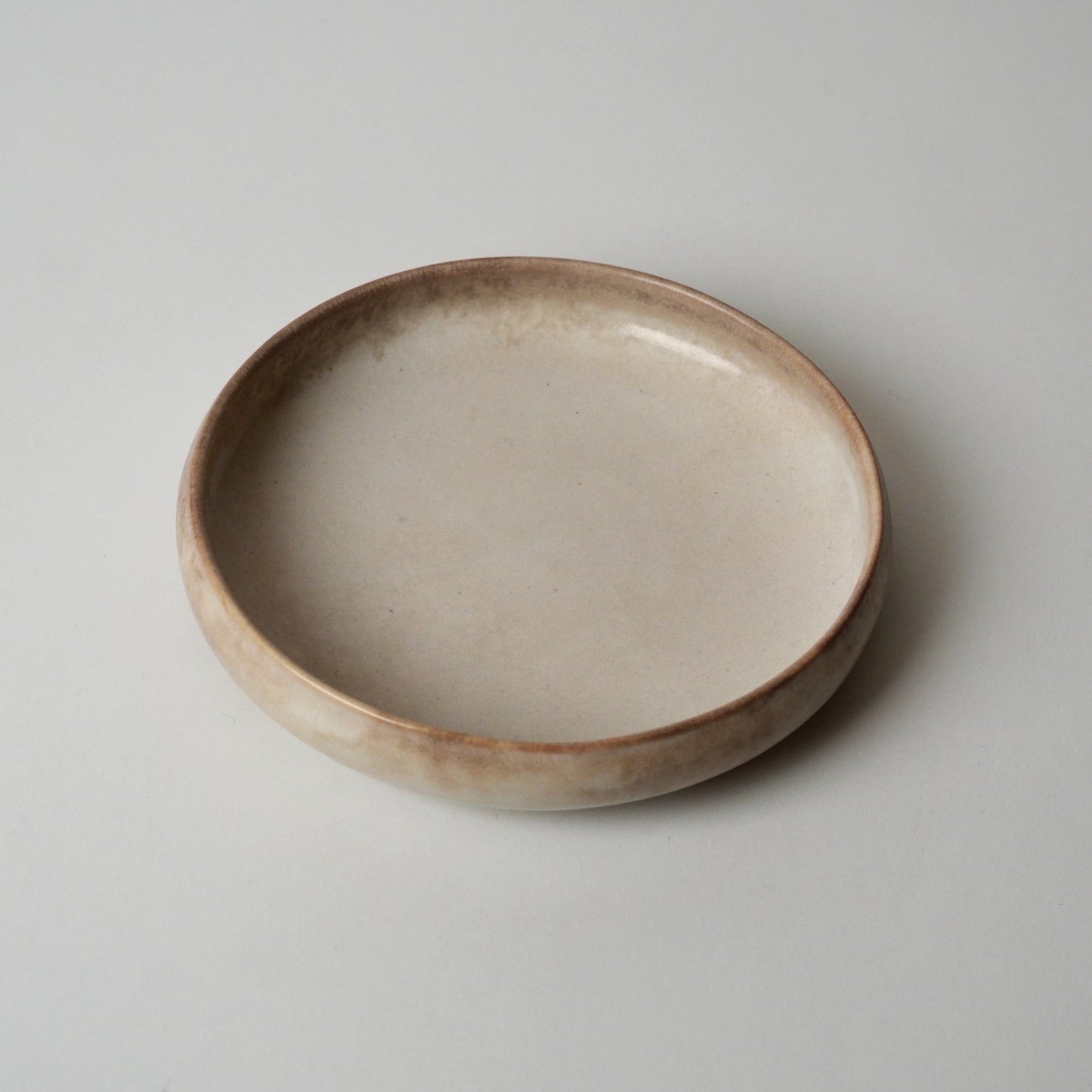 Ceramic bowl with a rustic finish on a plain background