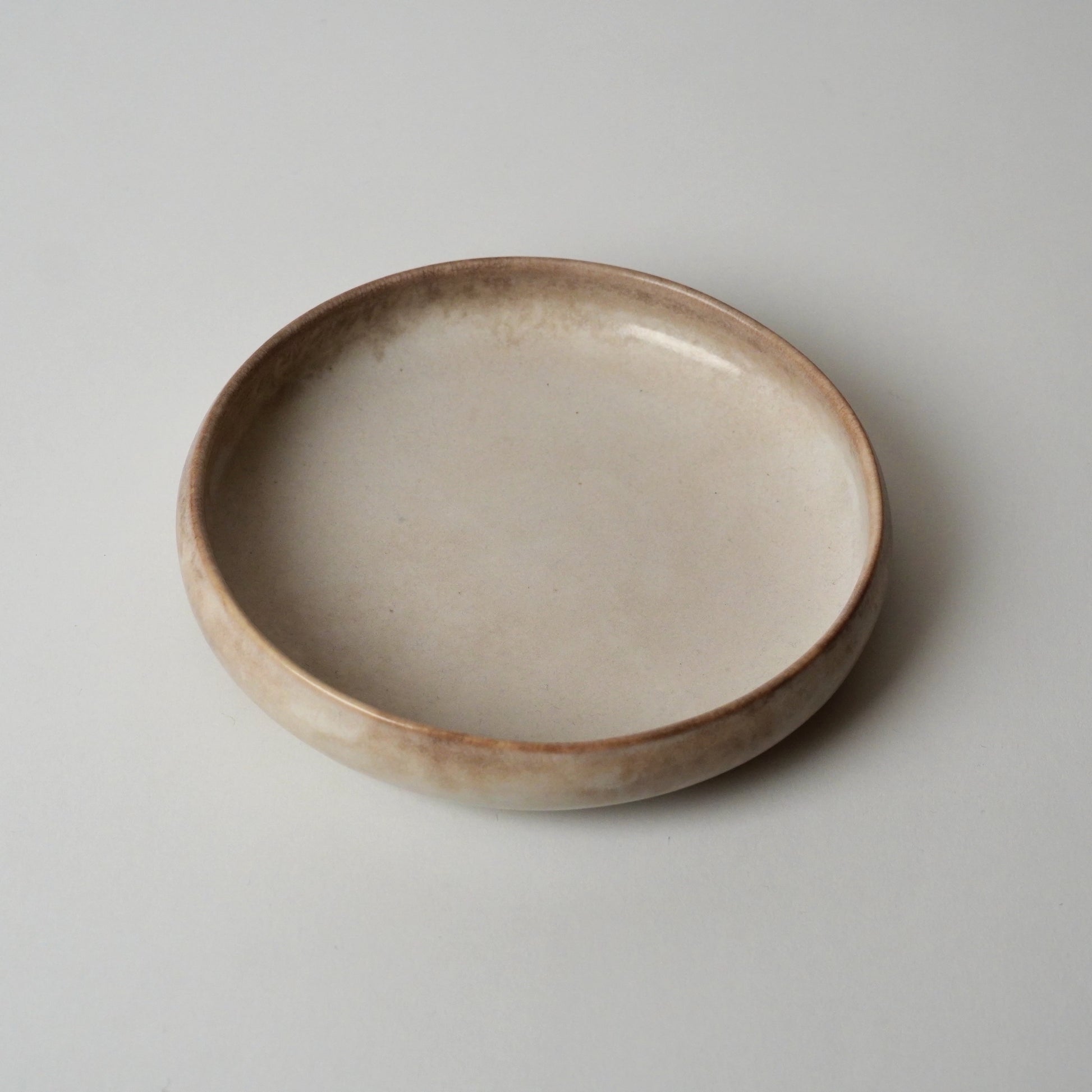 Ceramic bowl with a rustic finish on a plain background