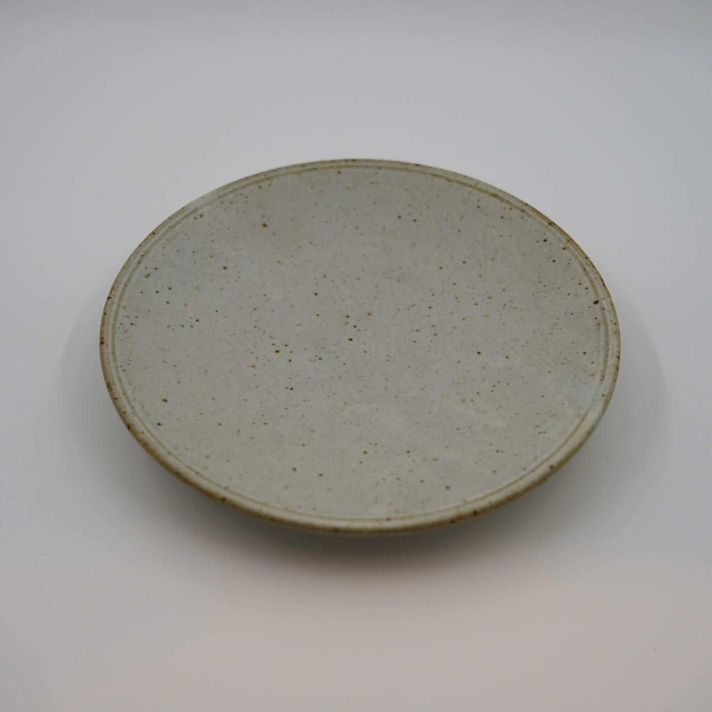 Round ceramic plate with a textured surface on a white background
