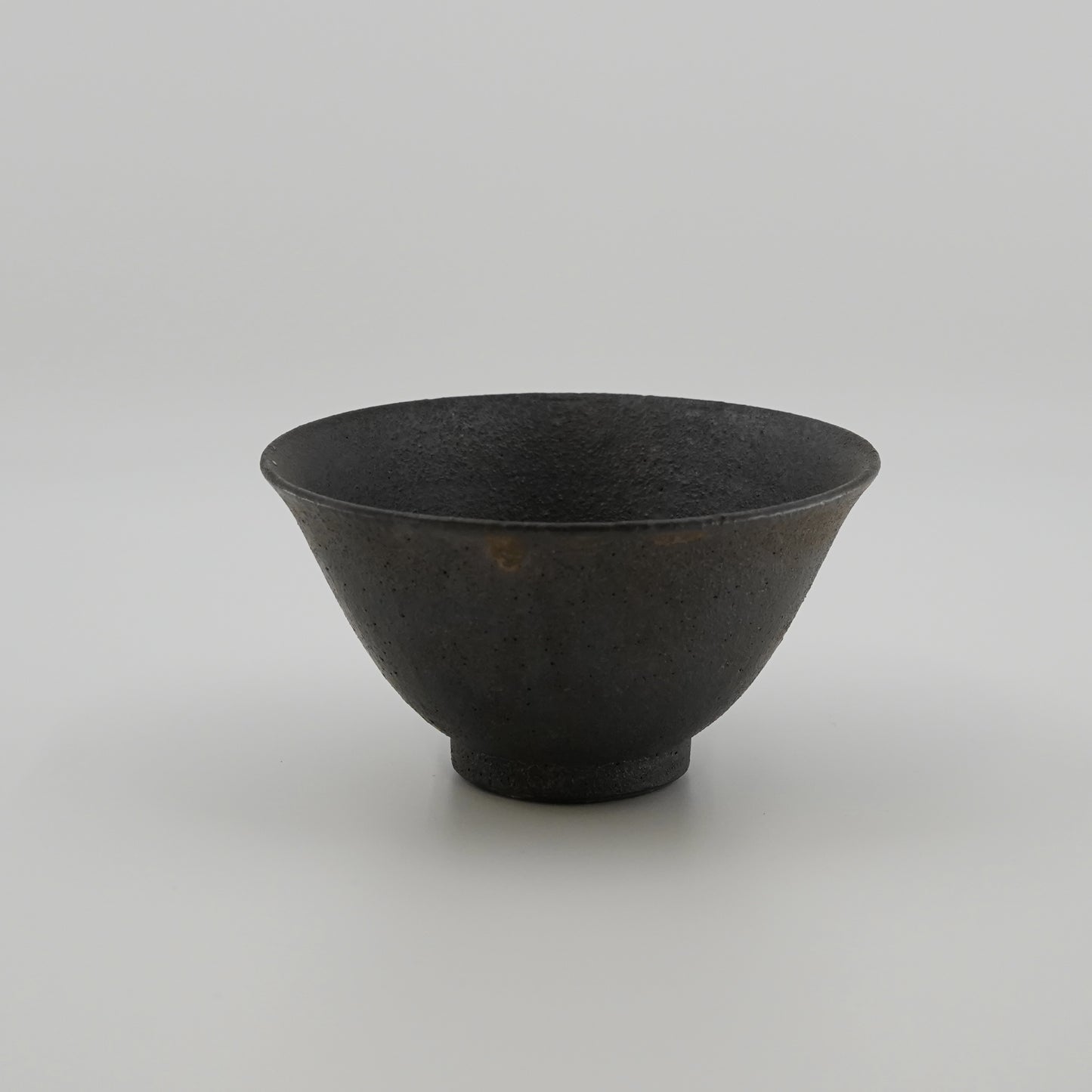 Black ceramic bowl on a light gray background