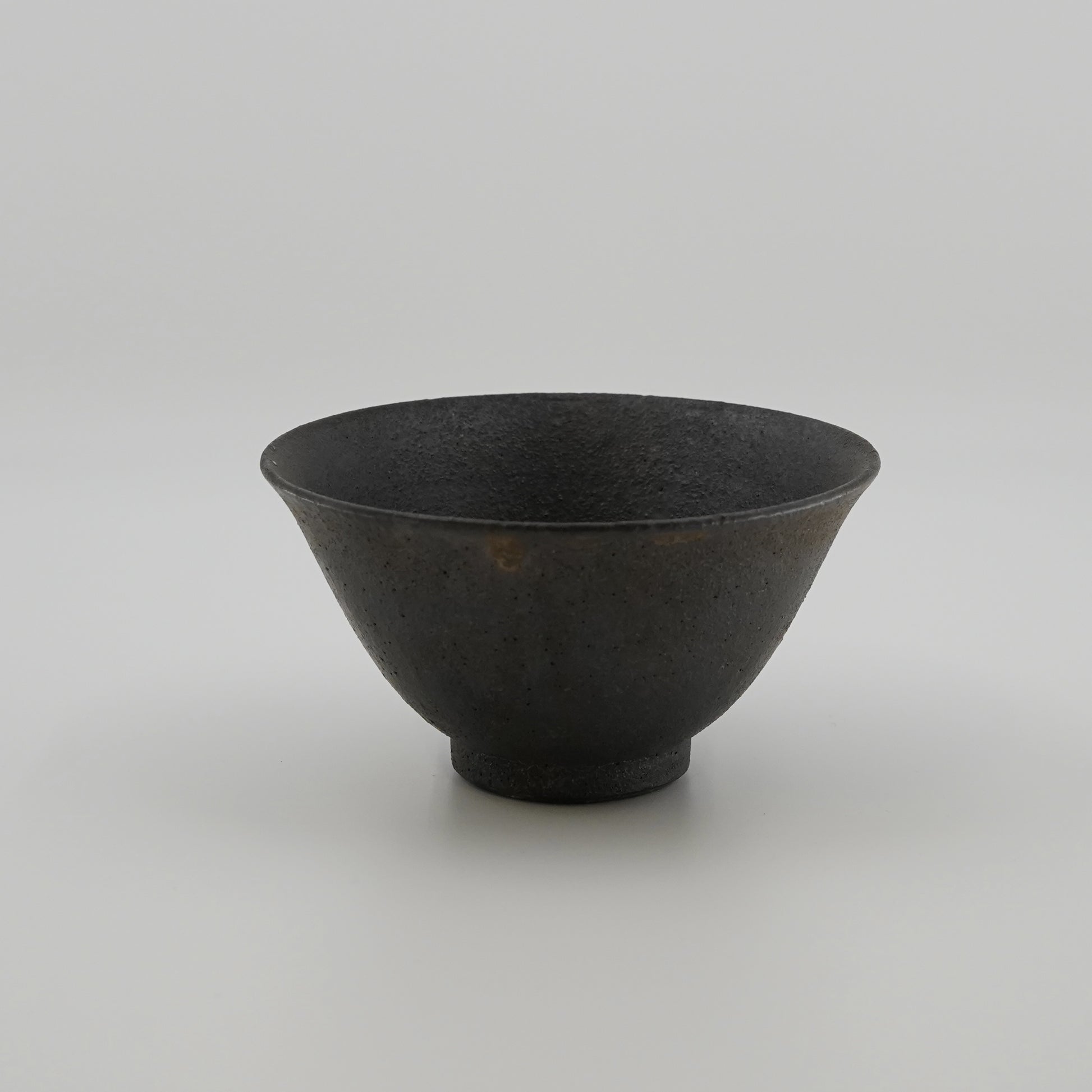 Black ceramic bowl on a light gray background