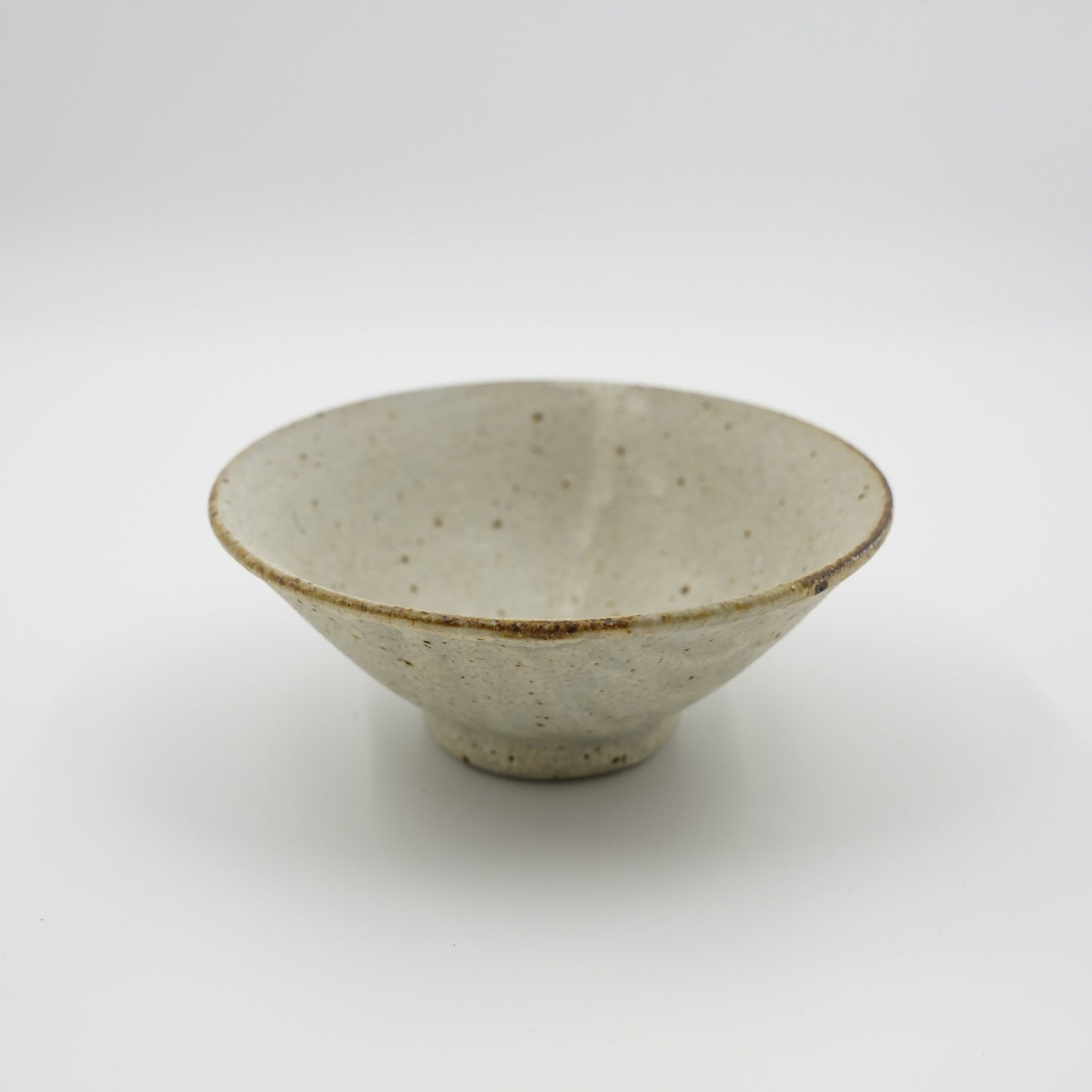 Ceramic bowl with speckled texture on a white background