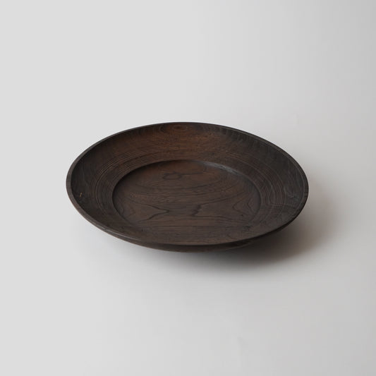 Dark wooden plate on a light gray background
