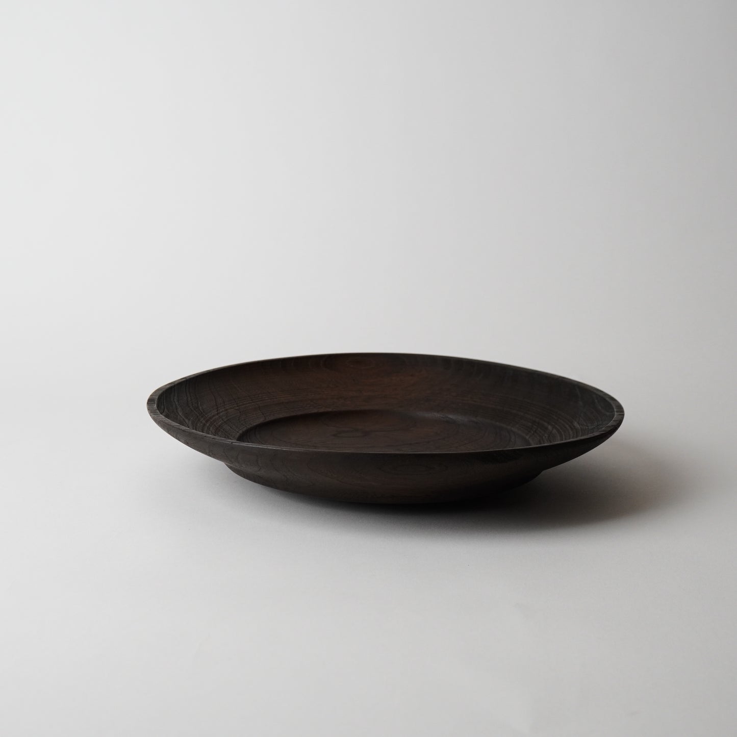 Dark wooden bowl on a light gray background