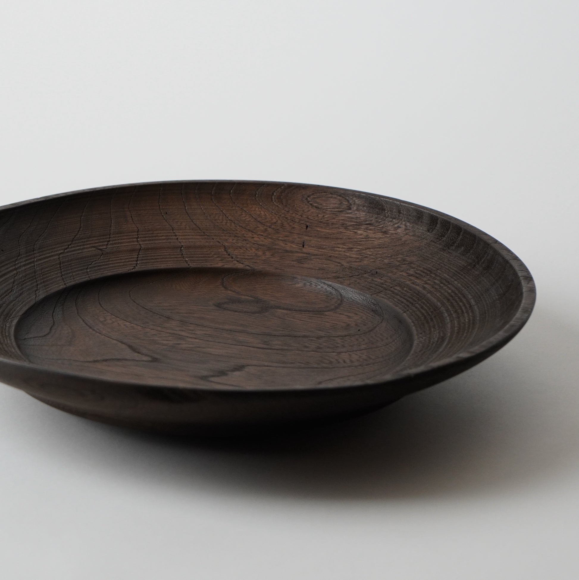 Dark wooden bowl on a light gray background