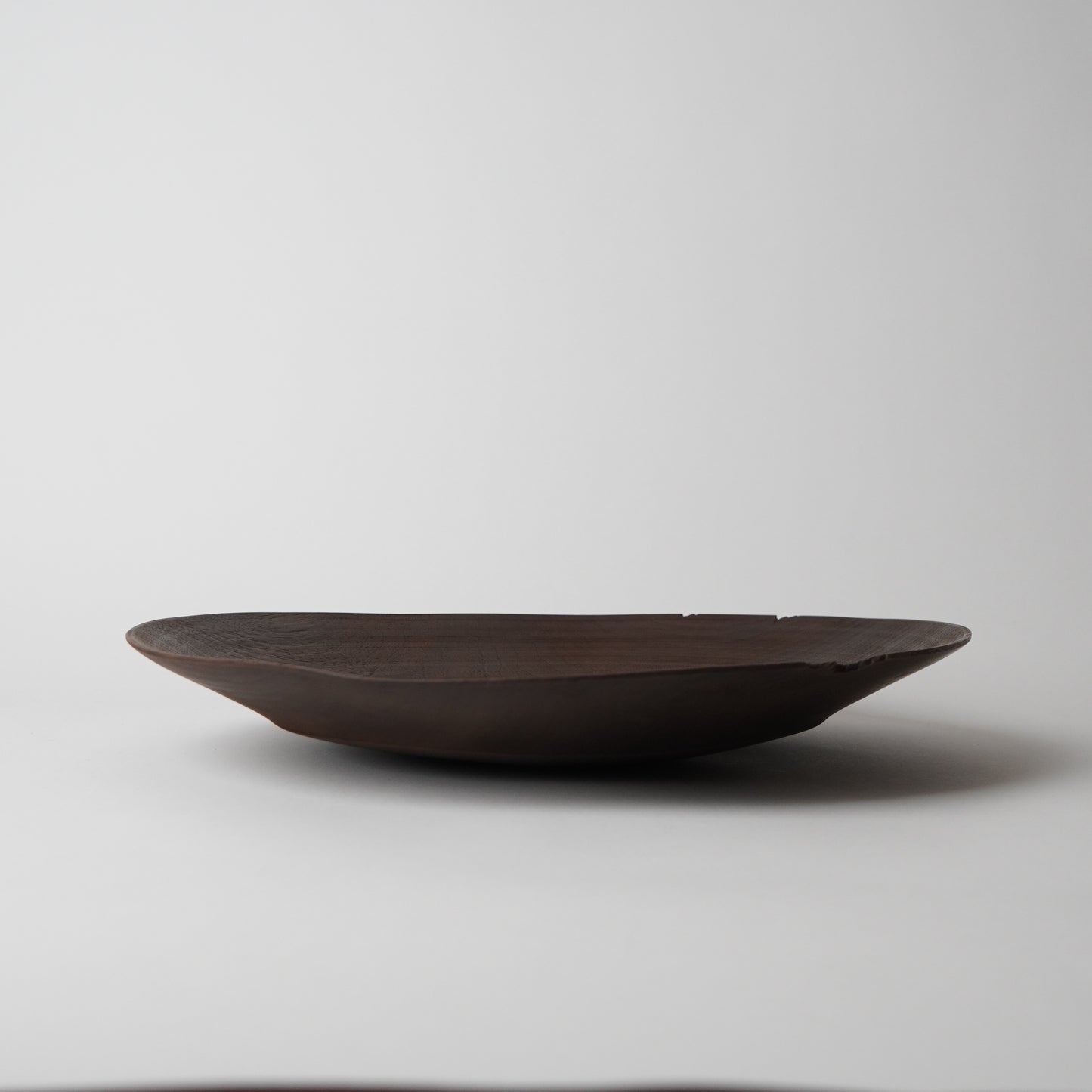 Dark brown ceramic bowl on a light gray background