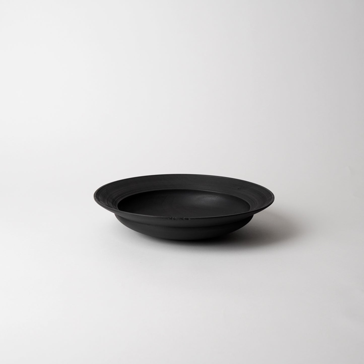 Black wooden bowl on a white background