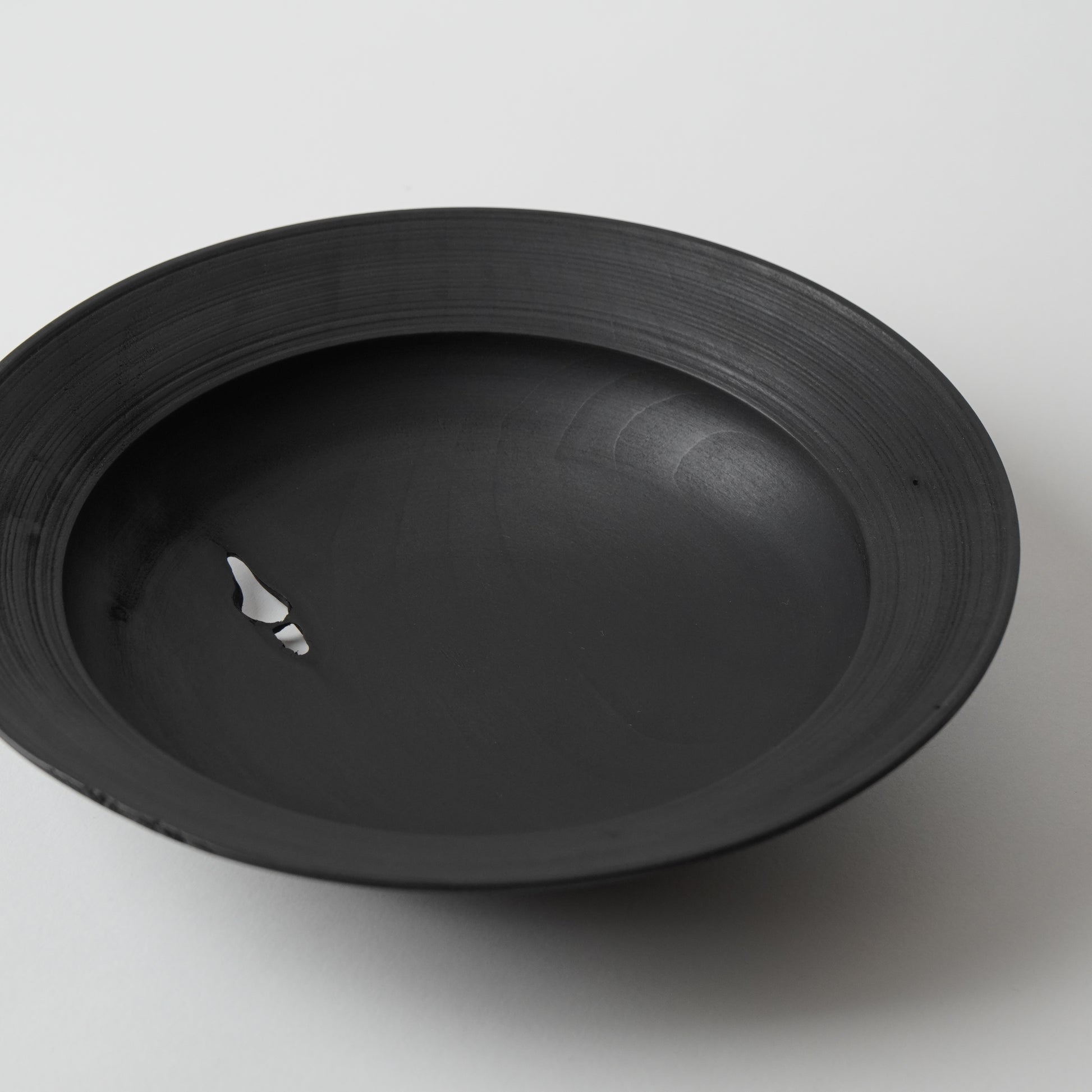 Black wooden plate on a white background