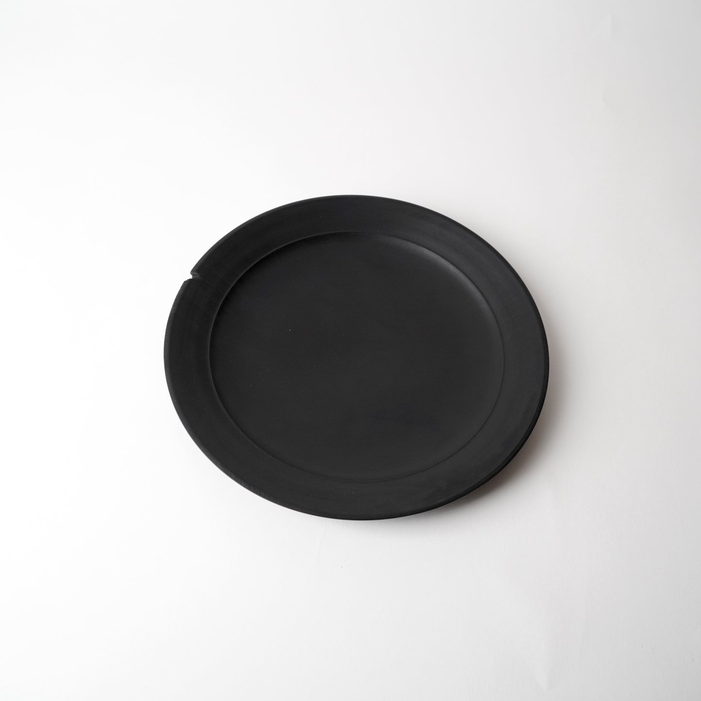 Black round plate on a white background