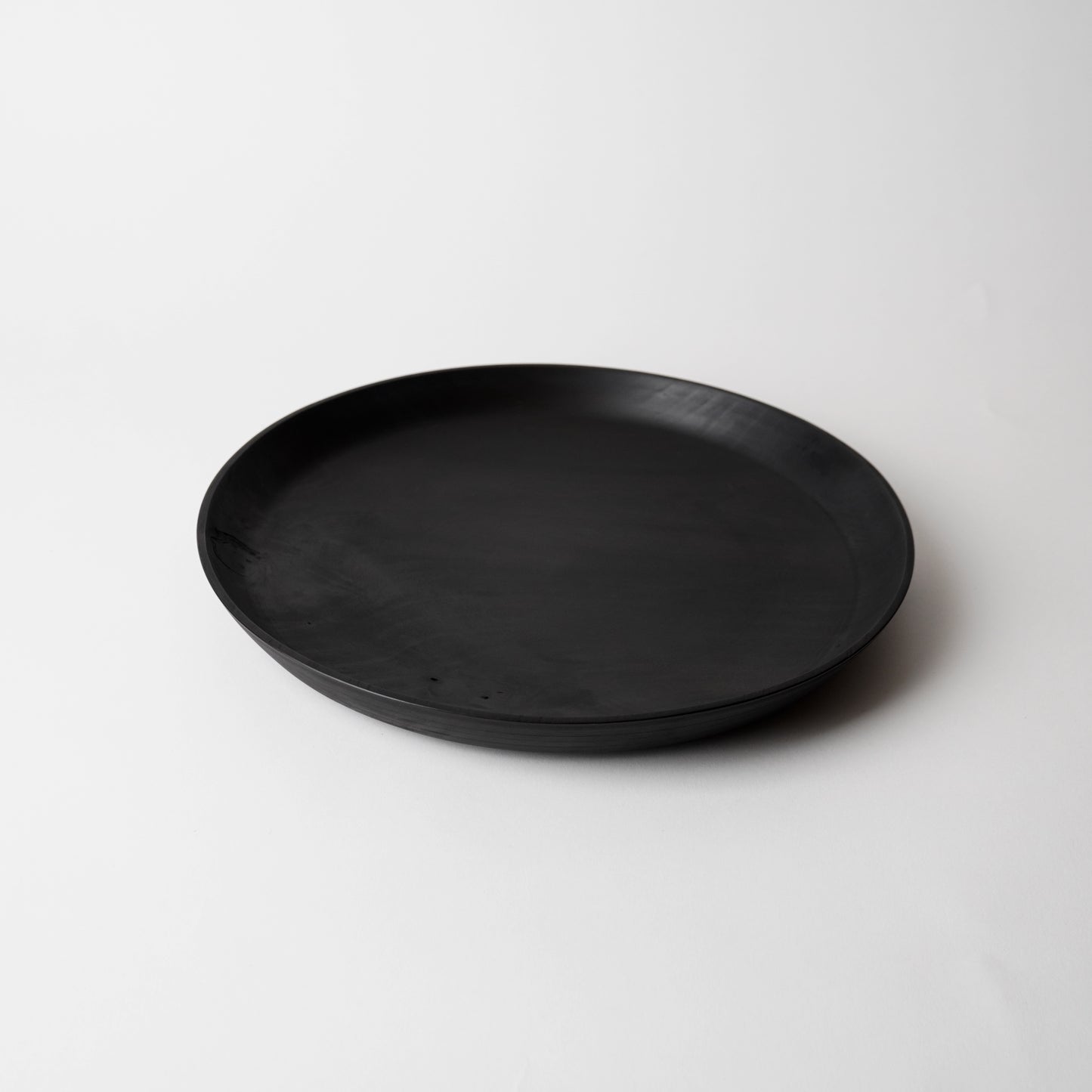 Black wooden plate on a white background