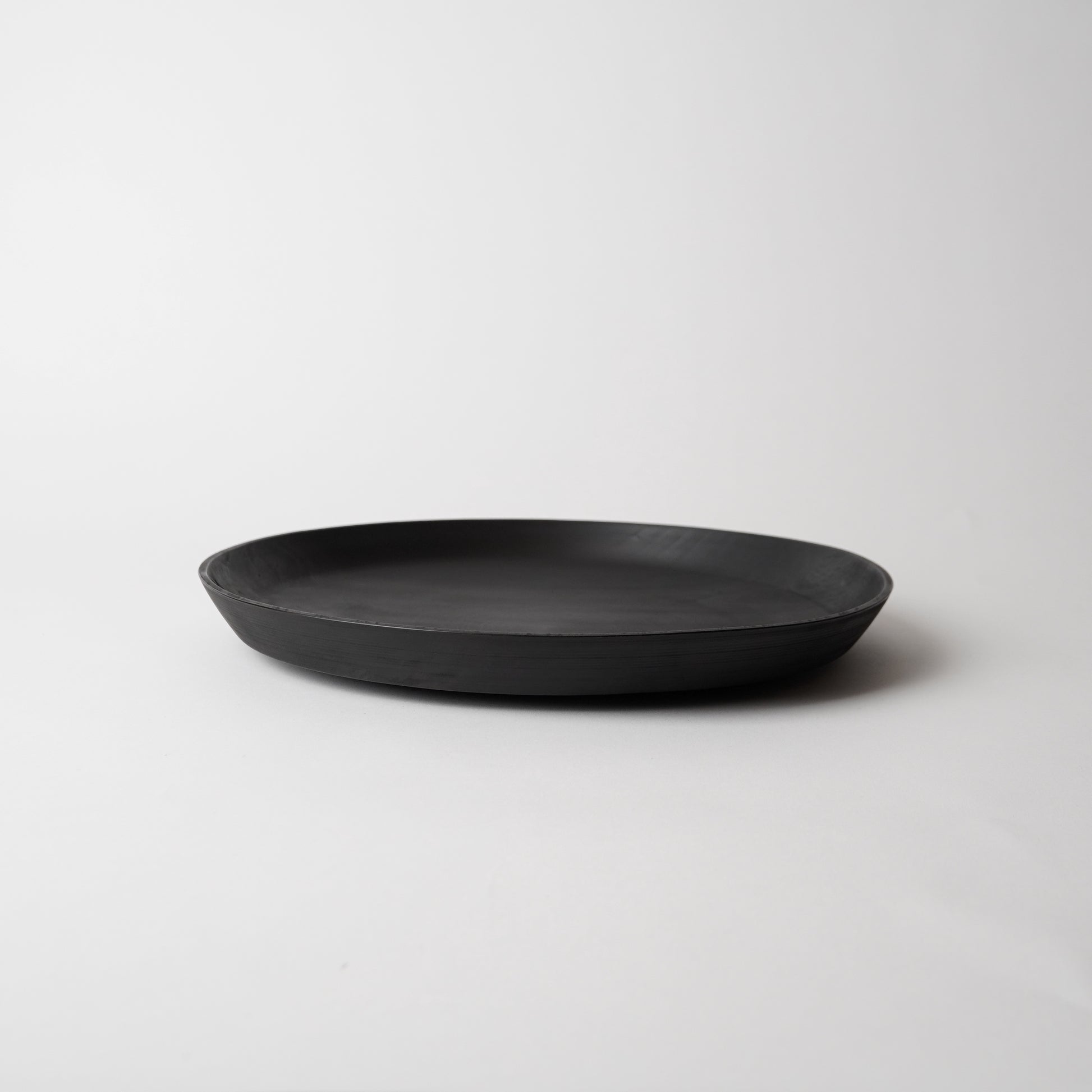 Black wooden plate on a light gray background