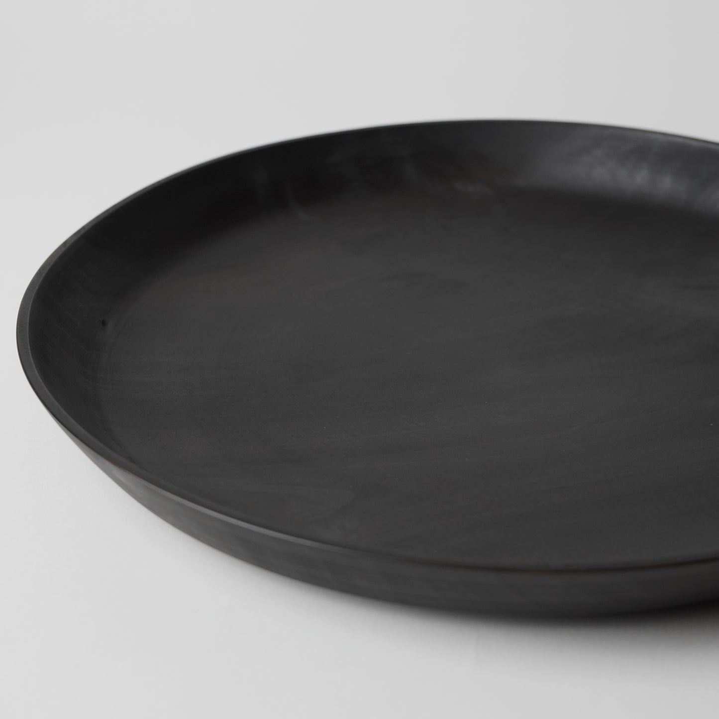 Black round tray on a light gray background