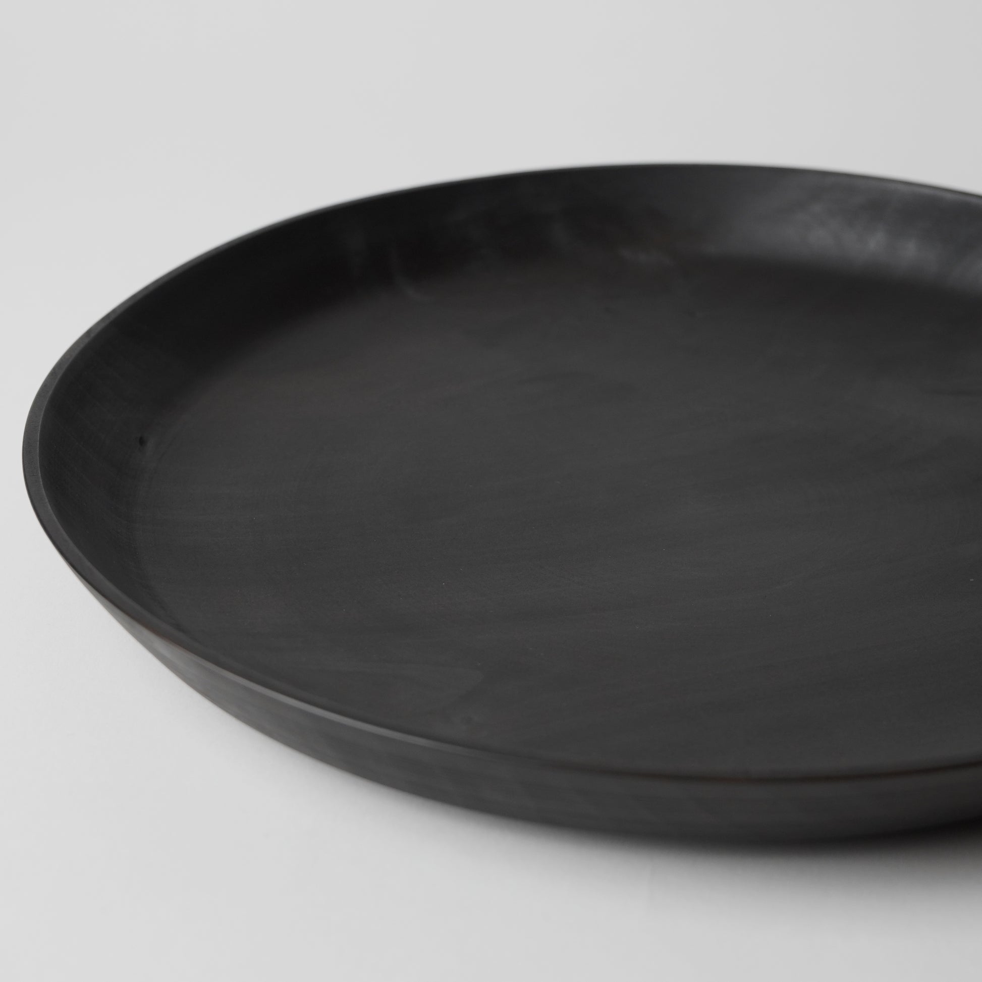 Black round tray on a light gray background