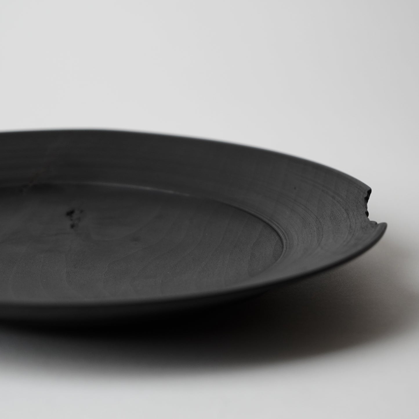 Black wooden plate on a light gray background