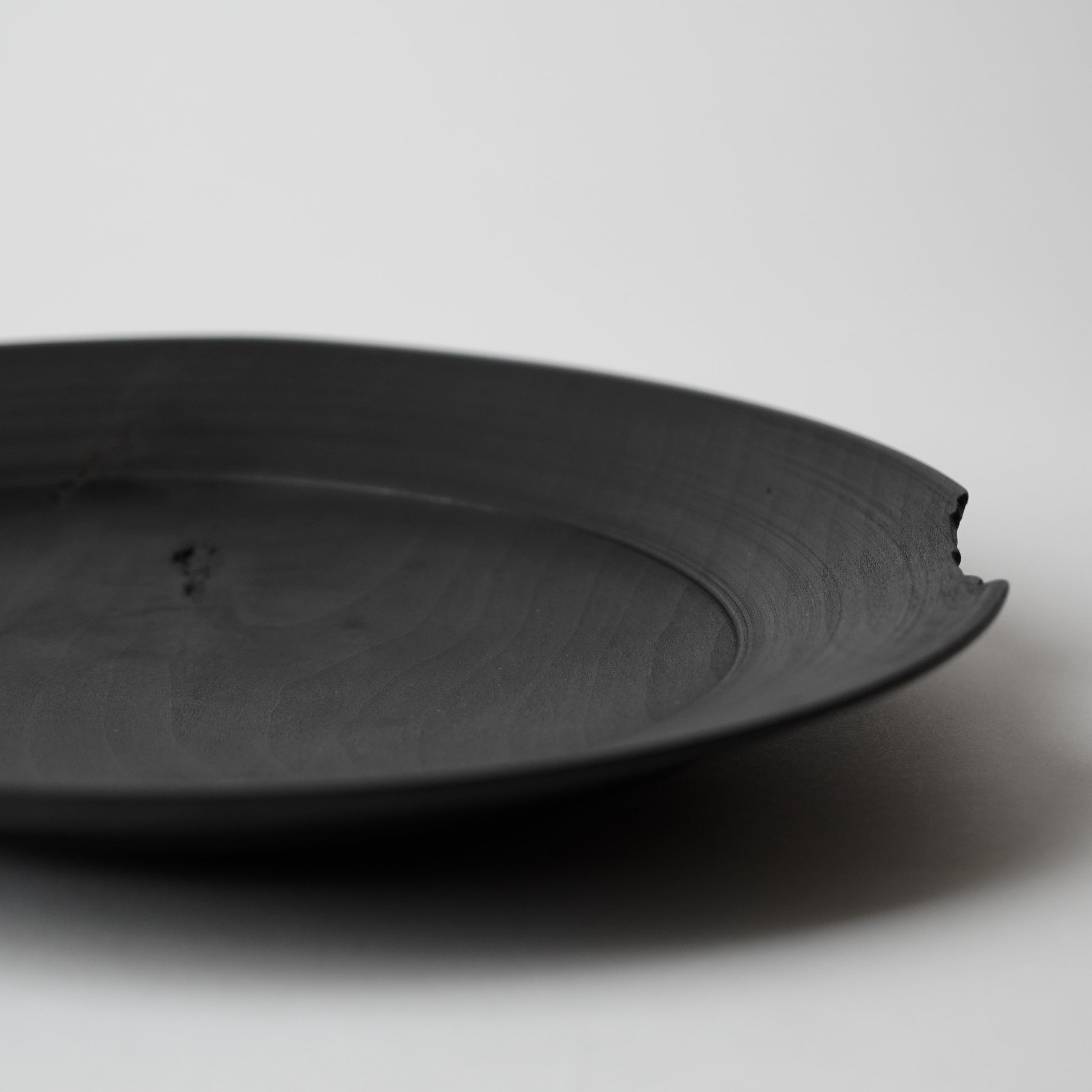 Black wooden plate on a light gray background
