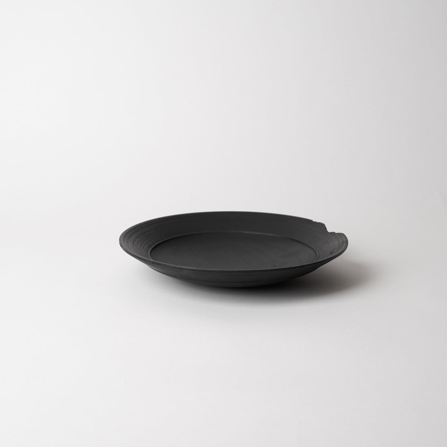 Black wooden bowl on a light gray background