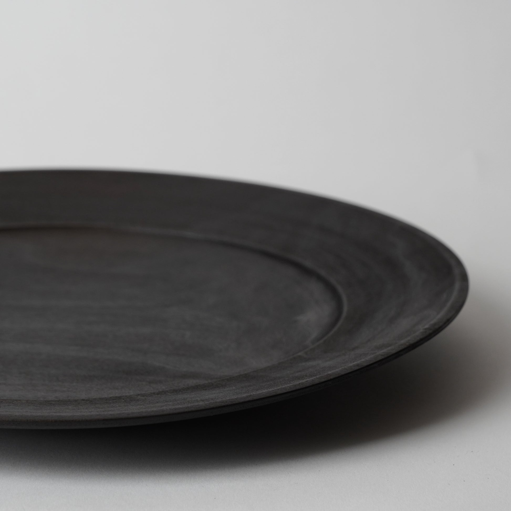 Black wooden plate on a light gray background