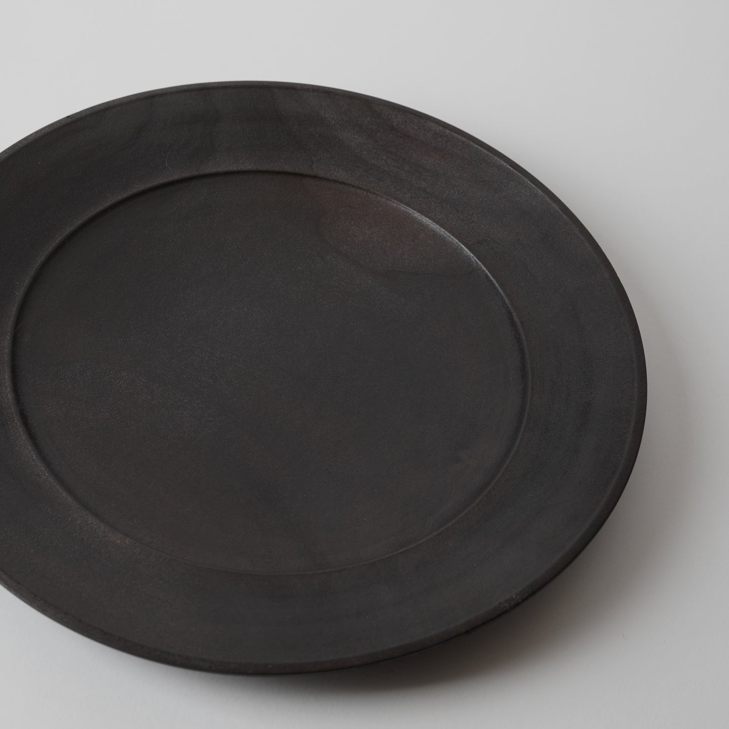 Black wooden plate on a light gray background