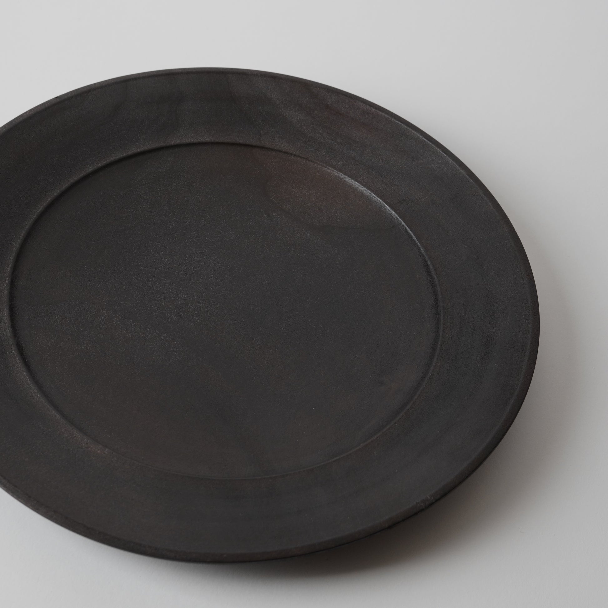 Black wooden plate on a light gray background
