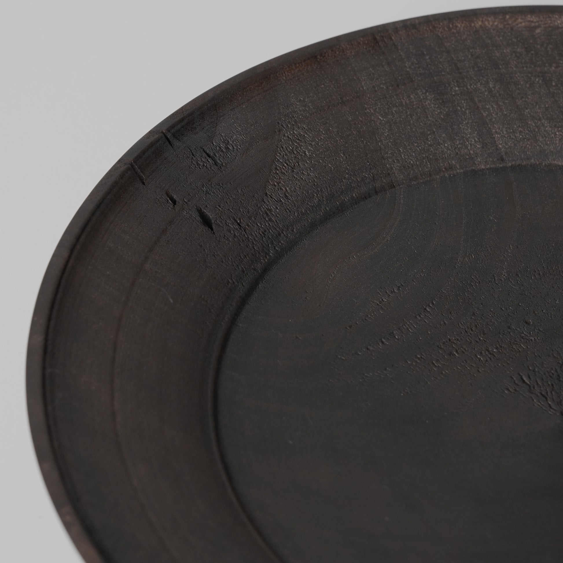 Close-up of a dark gray or black circular object on a light gray background