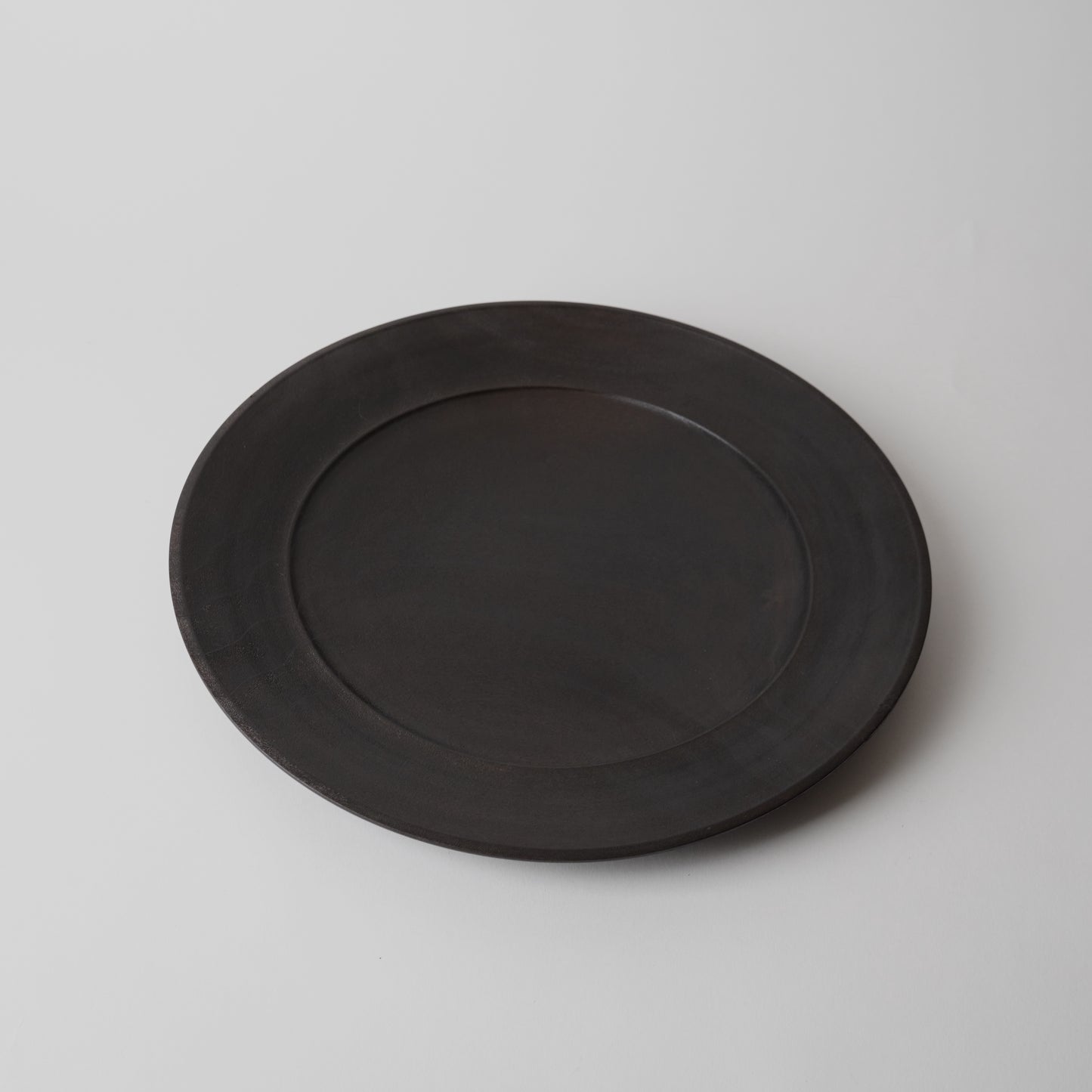Black wooden plate on a light gray background