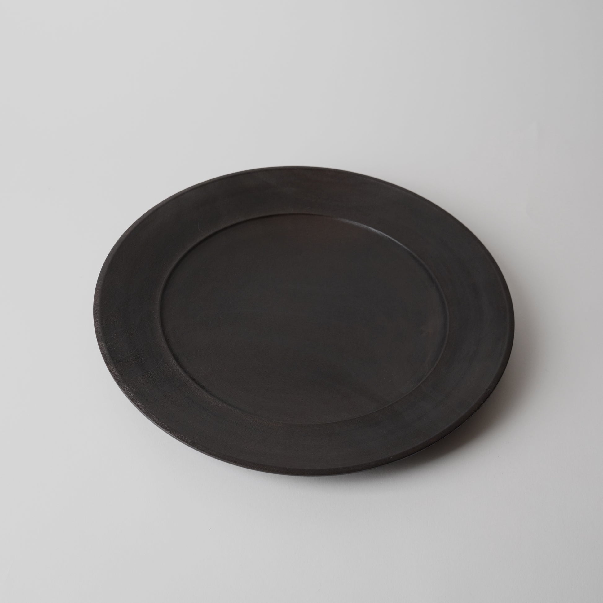 Black wooden plate on a light gray background