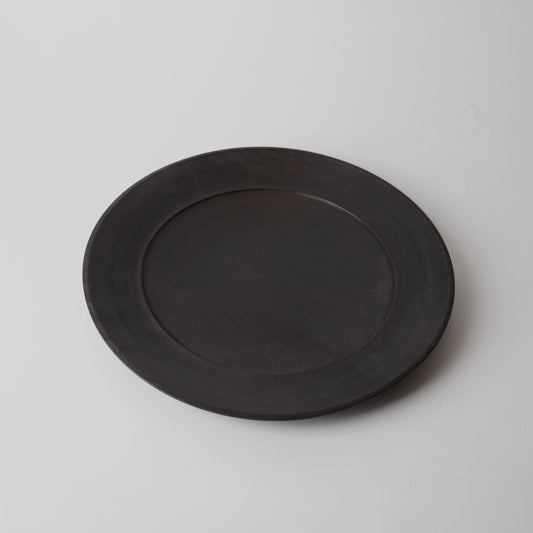 Black wooden plate on a light gray background