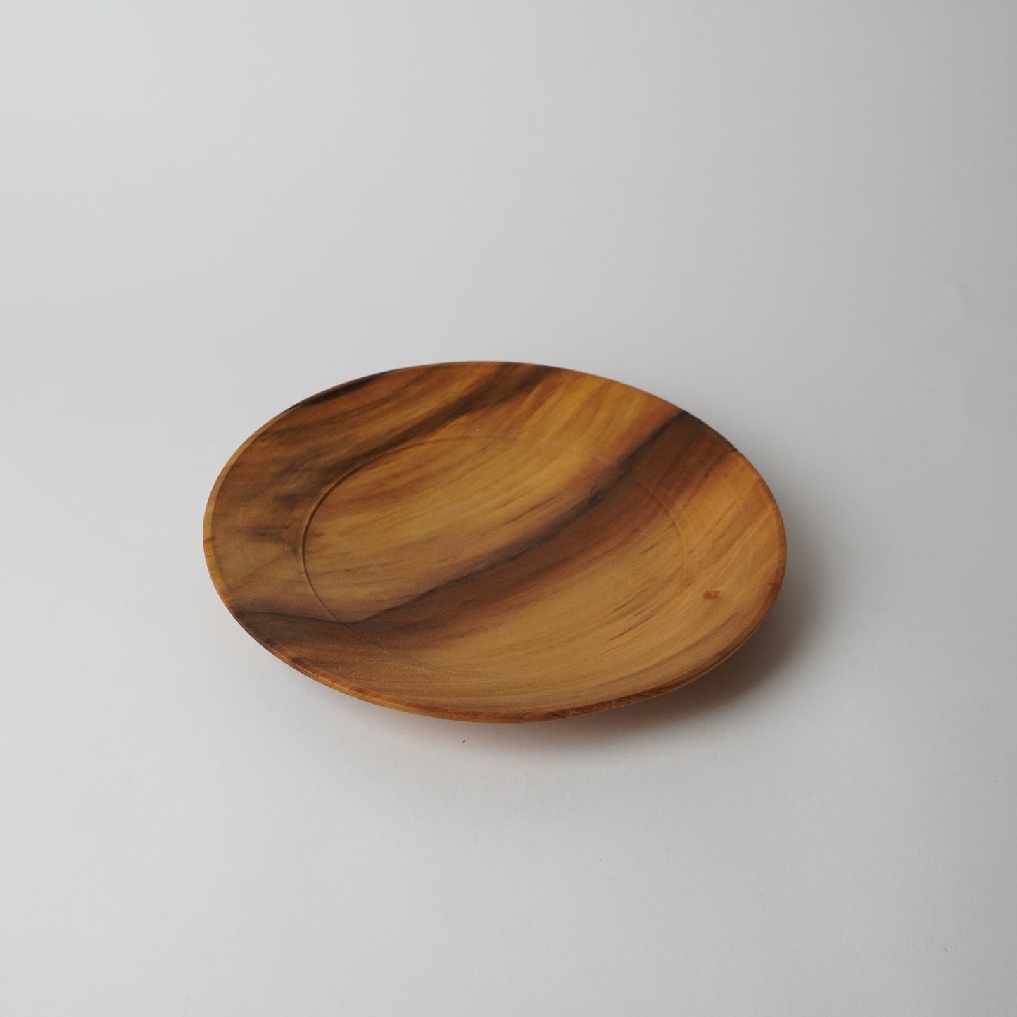 Wooden plate with a wavy design on a light gray background