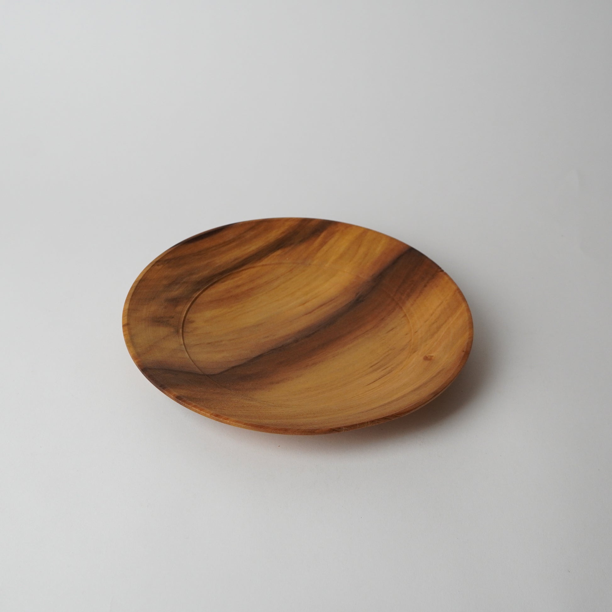 Wooden plate with a wavy design on a light gray background