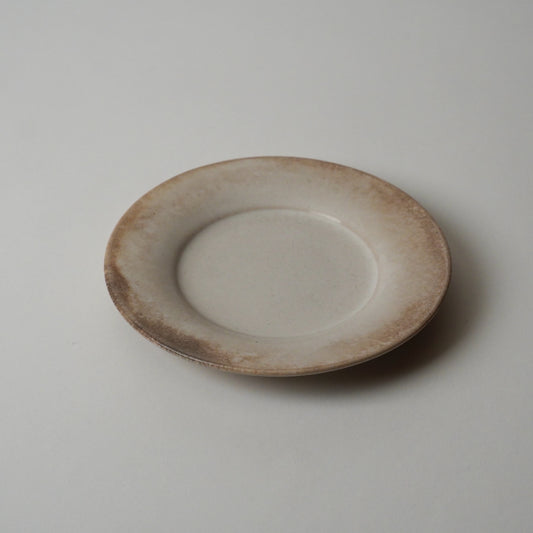 Ceramic plate with a textured rim on a plain background