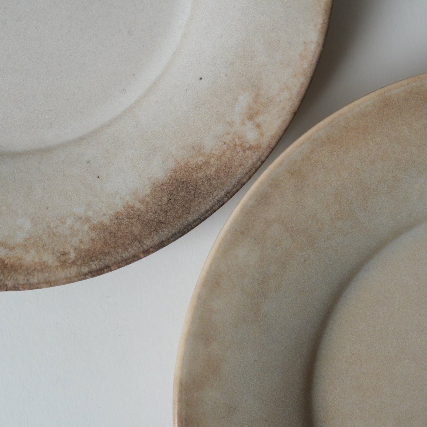 Two ceramic plates with a rustic finish on a light background