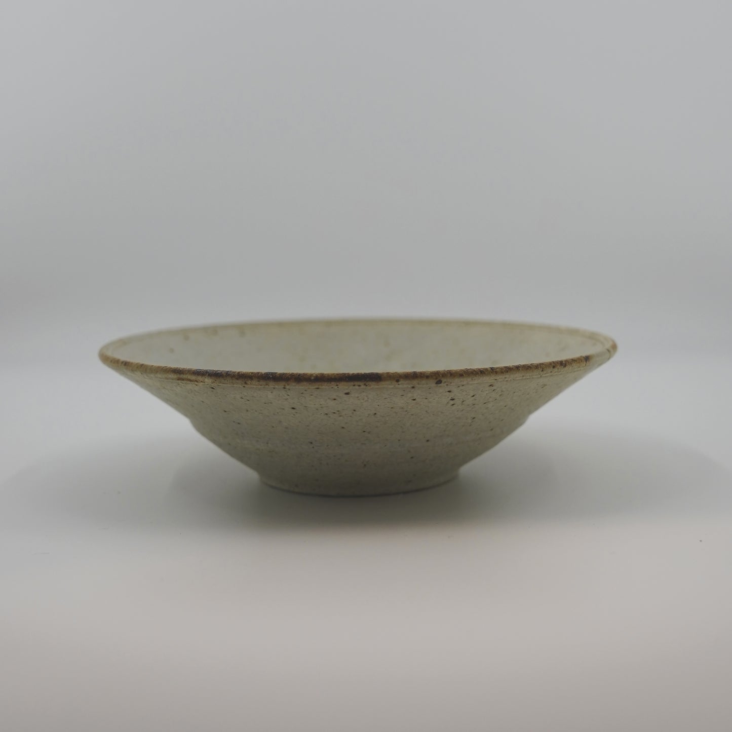 Ceramic bowl with speckled texture on a white background