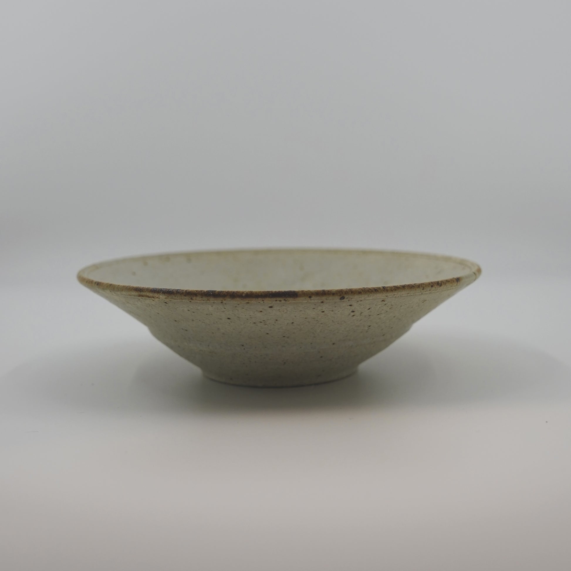 Ceramic bowl with speckled texture on a white background