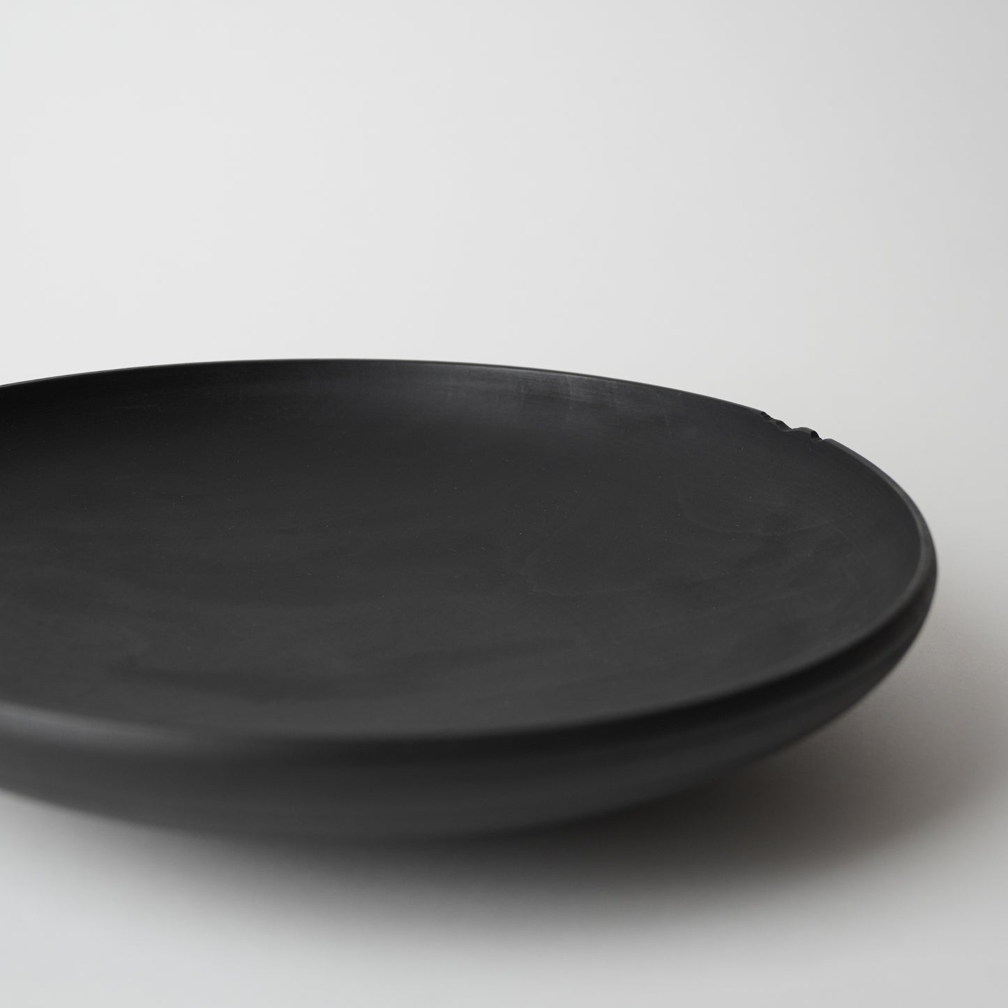 Black wooden plate on a white background