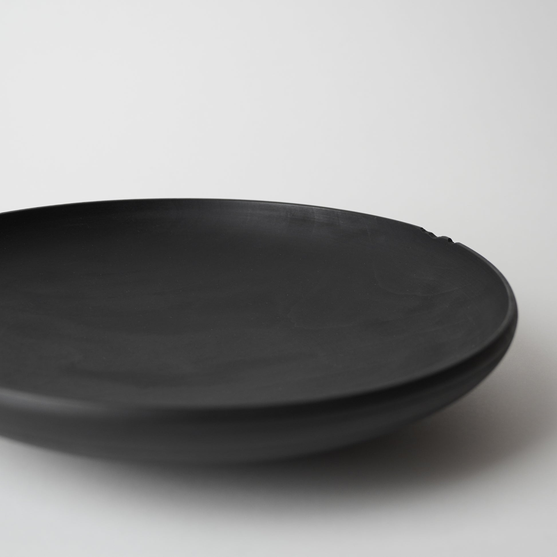 Black wooden plate on a white background