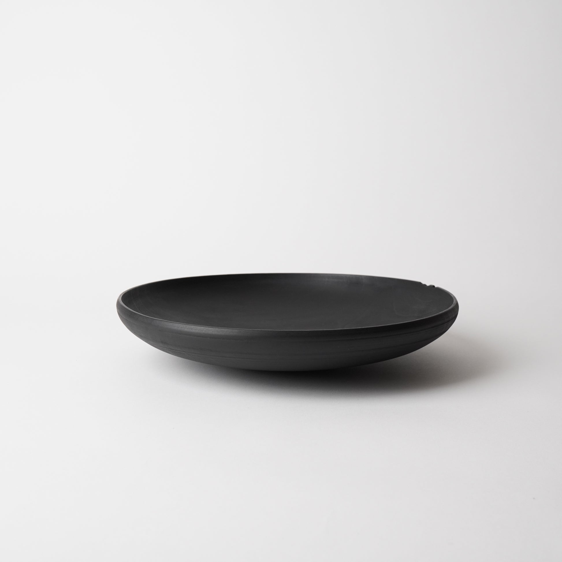 Black wooden bowl on a white background