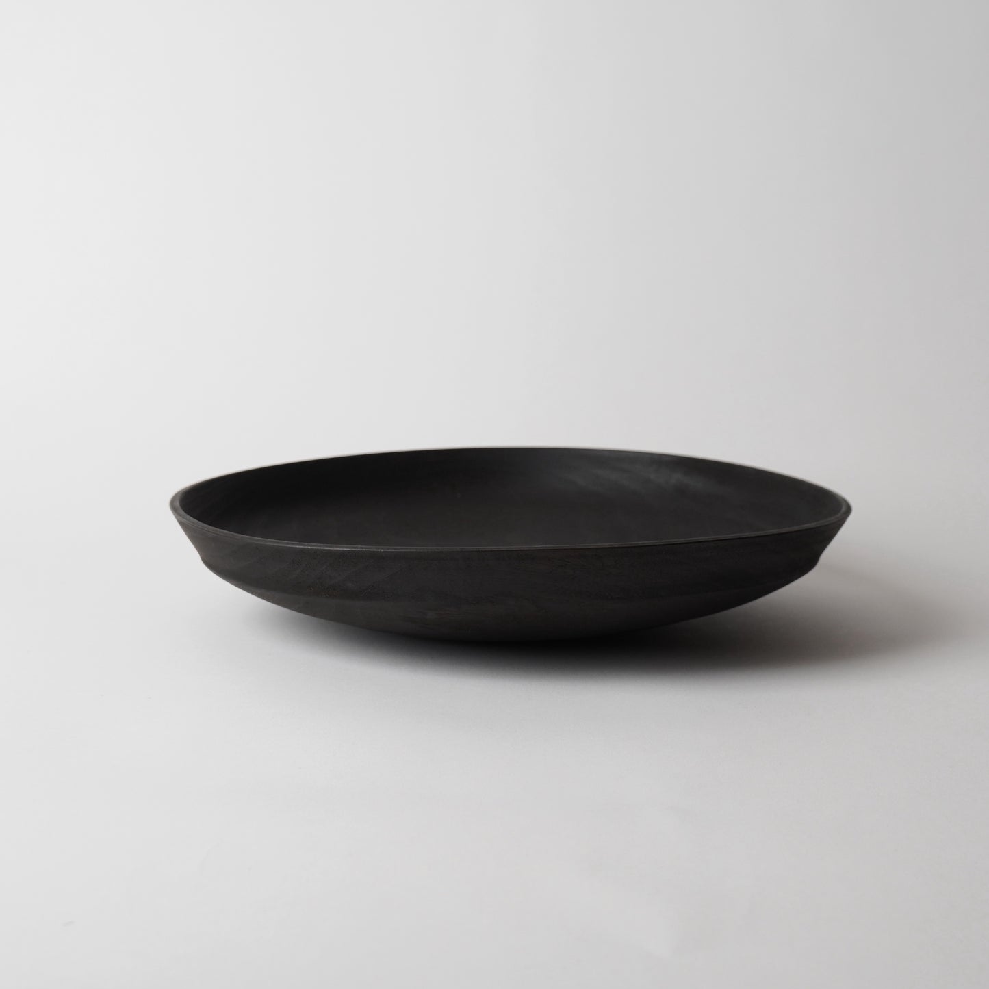 Black wooden plate on a light gray background
