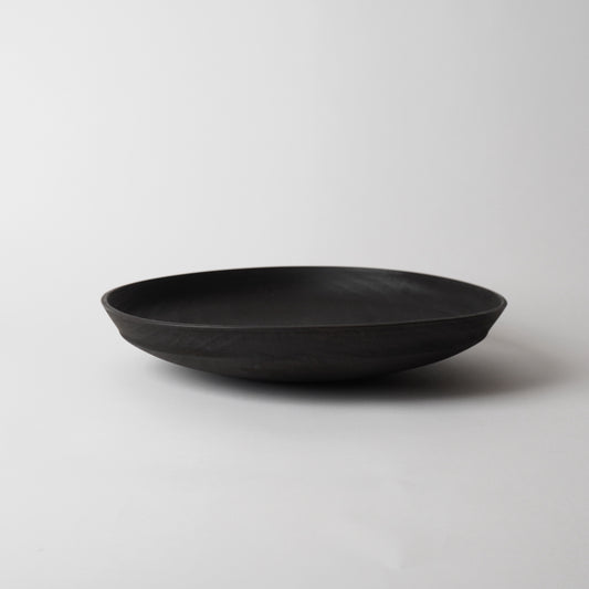 Black wooden plate on a light gray background