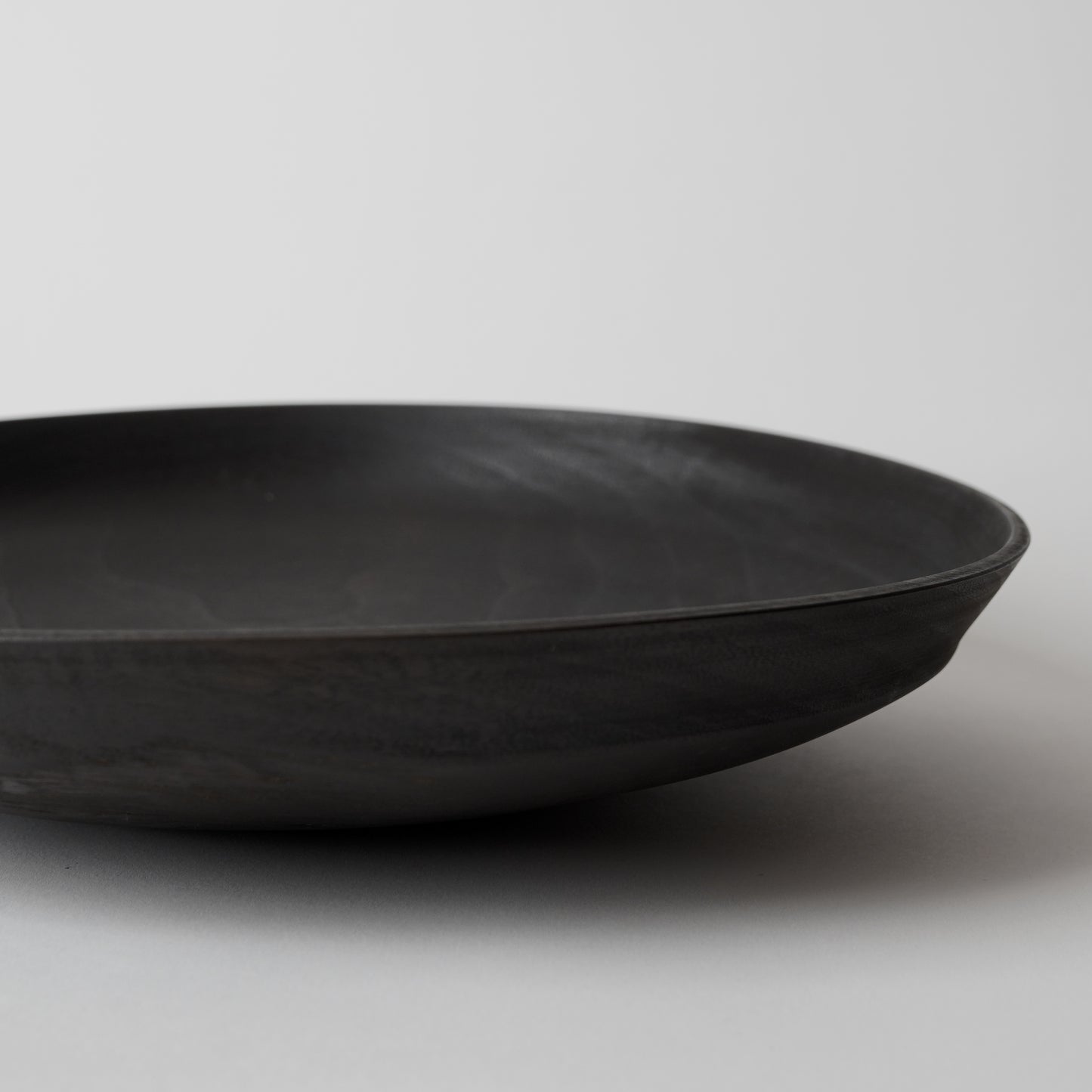 Black wooden bowl on a light gray background
