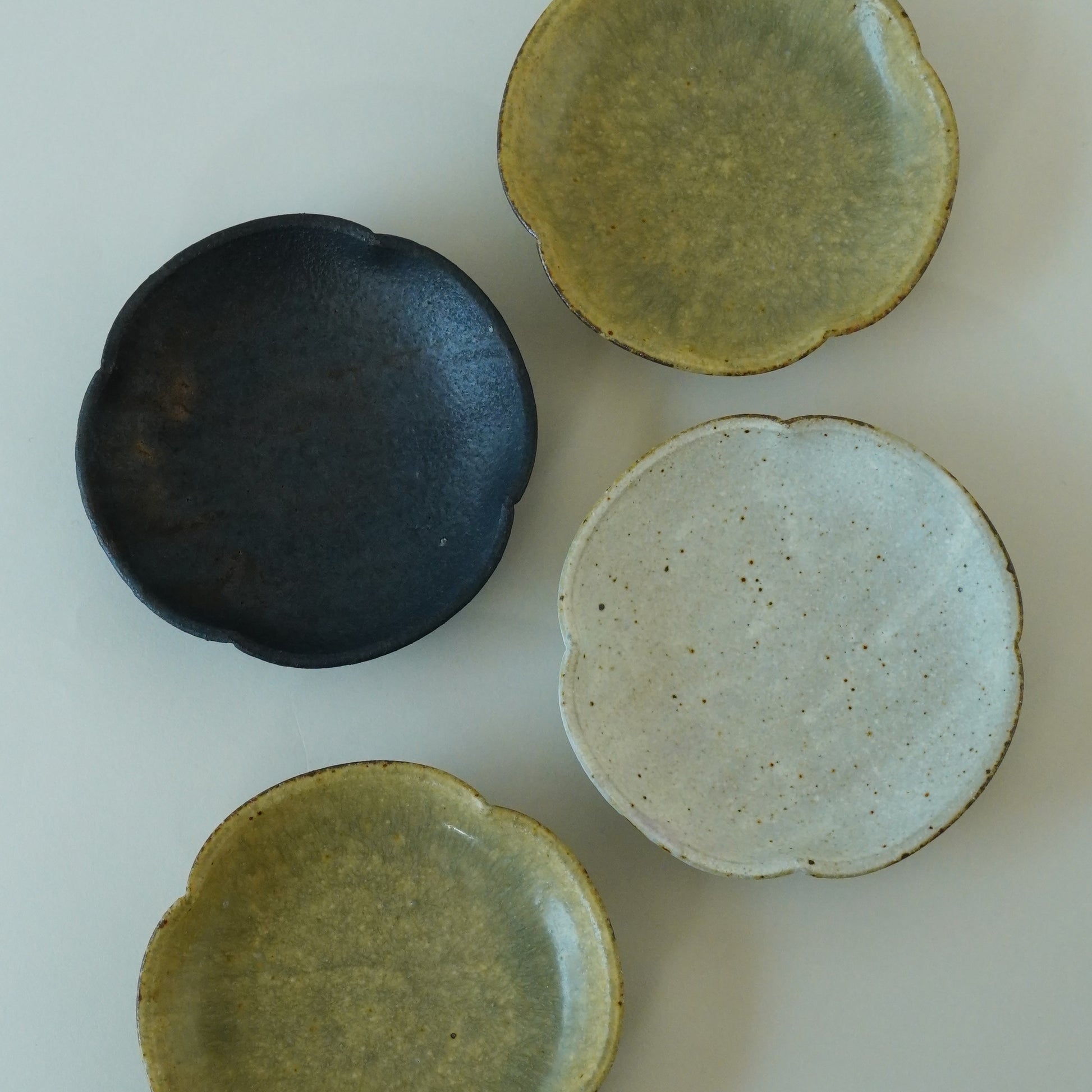 Four ceramic bowls in different colors on a light background. Handmade ceramic  plate by Japanese artist at Gallery tete Hong Kong.