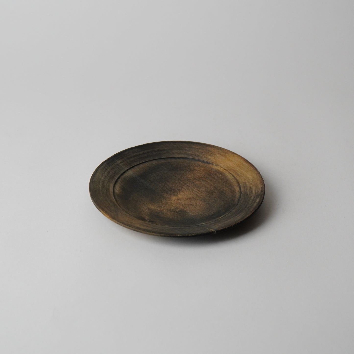 Round wooden plate on a light gray background