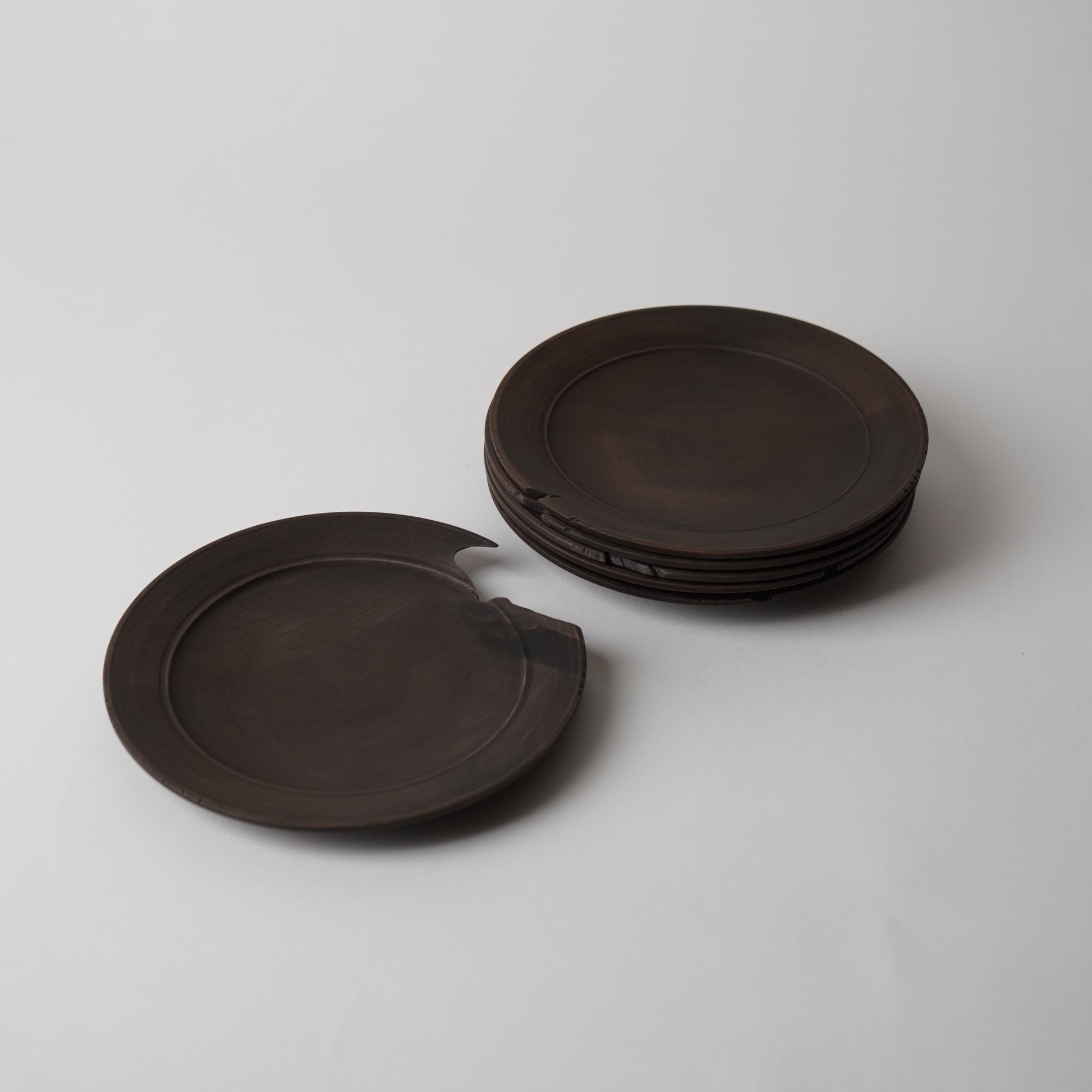 Set of dark brown wooden plates on a light gray background