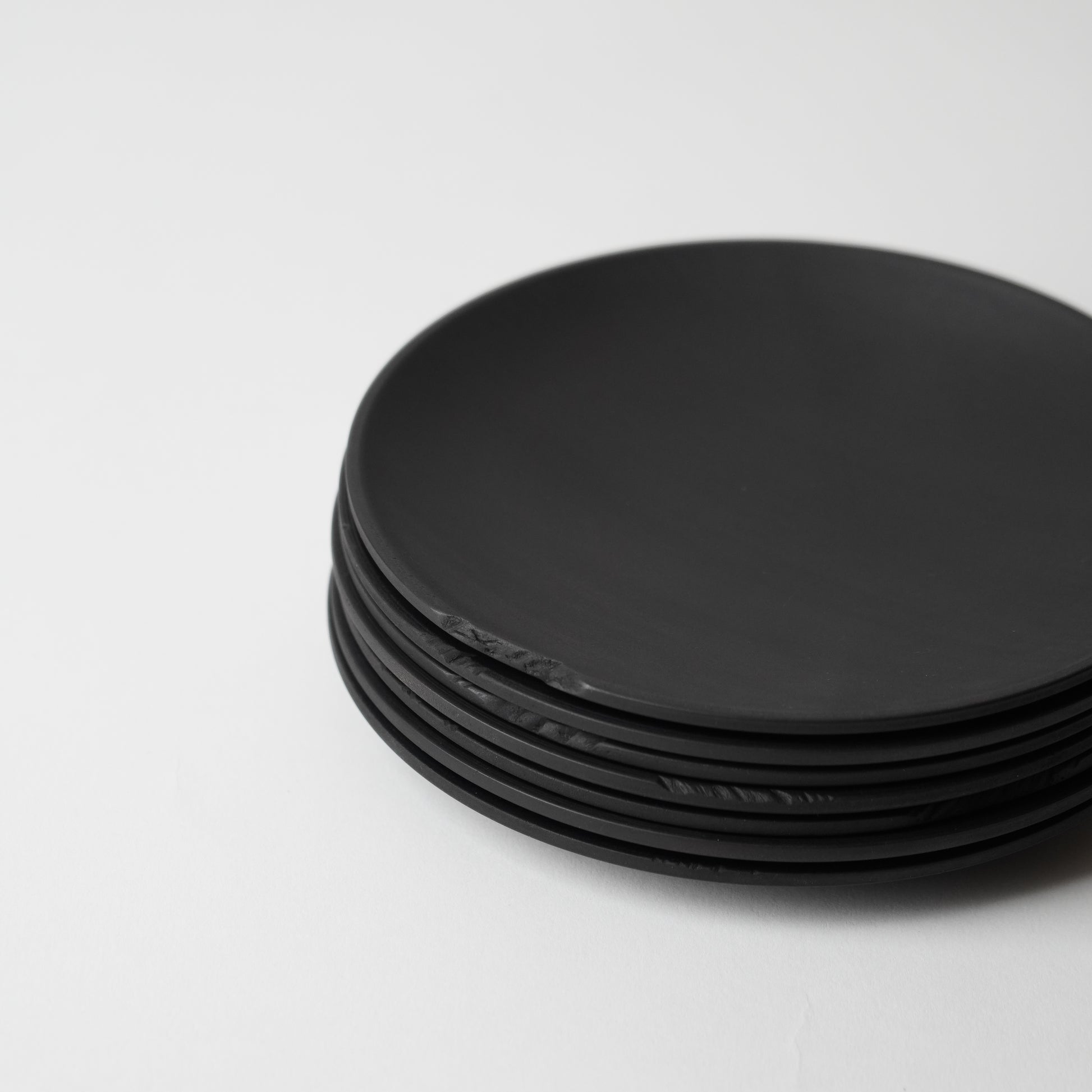 Stack of black round objects on a white background