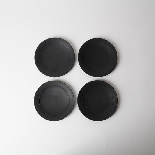 Four black wooden plates on a white background