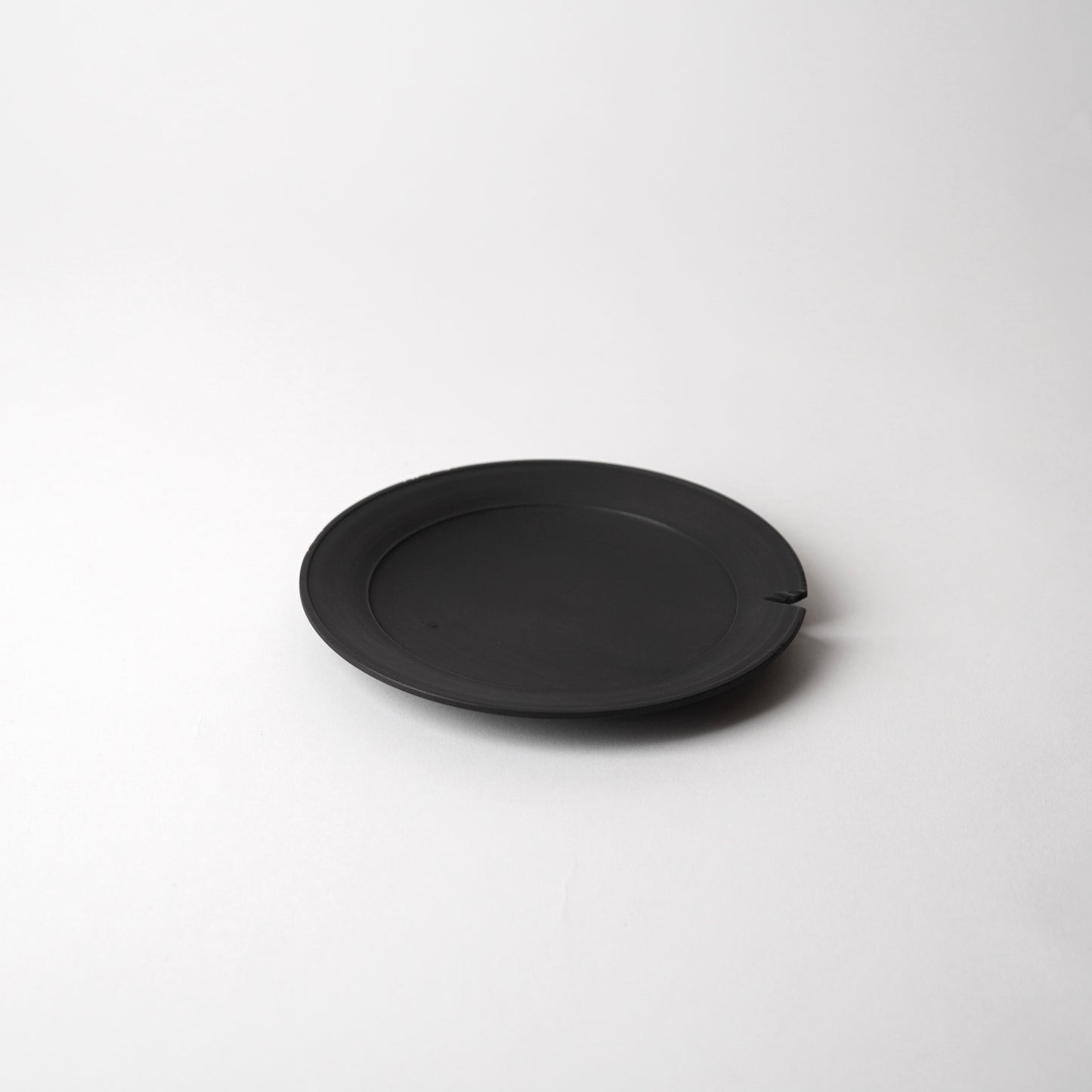 Black wooden plate on a white background