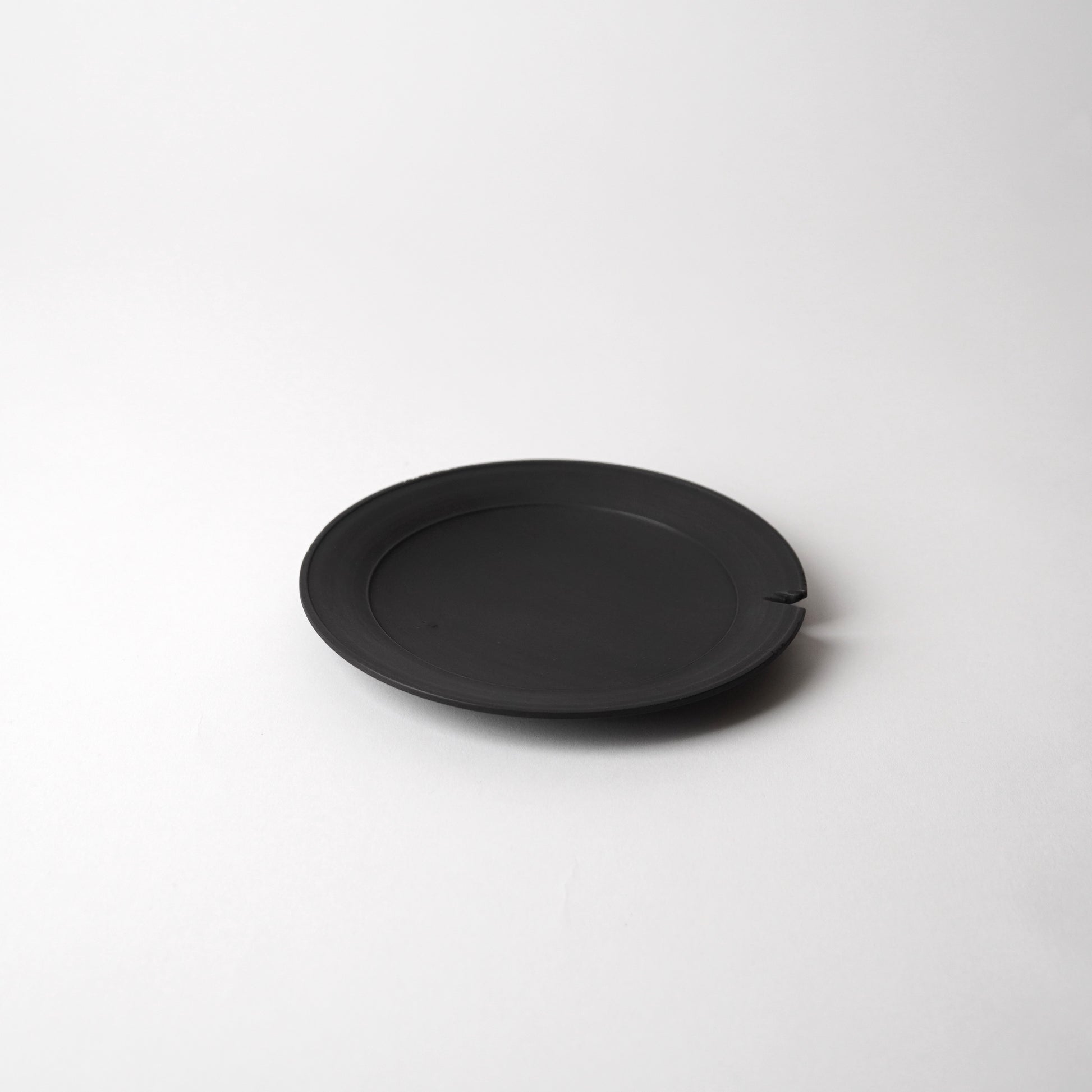 Black wooden plate on a white background