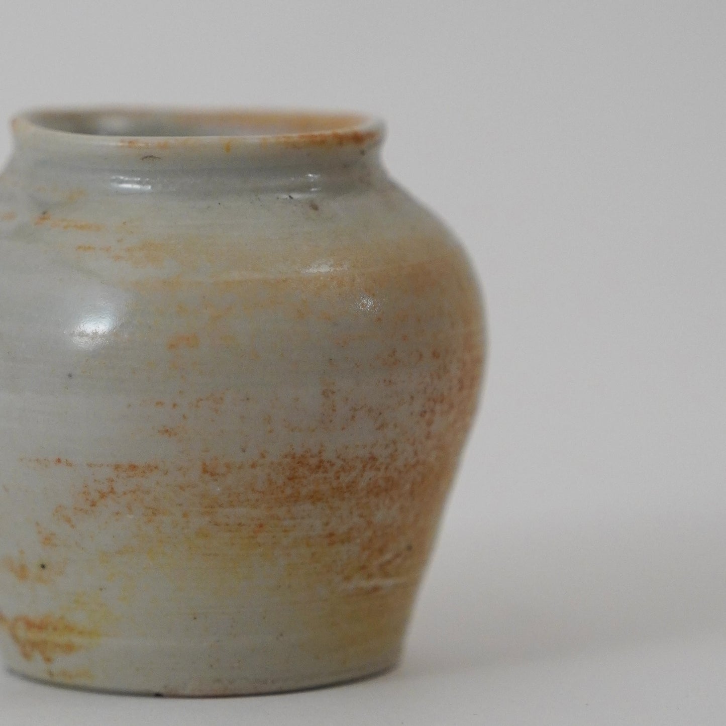 Ceramic jar with a textured surface on a plain background