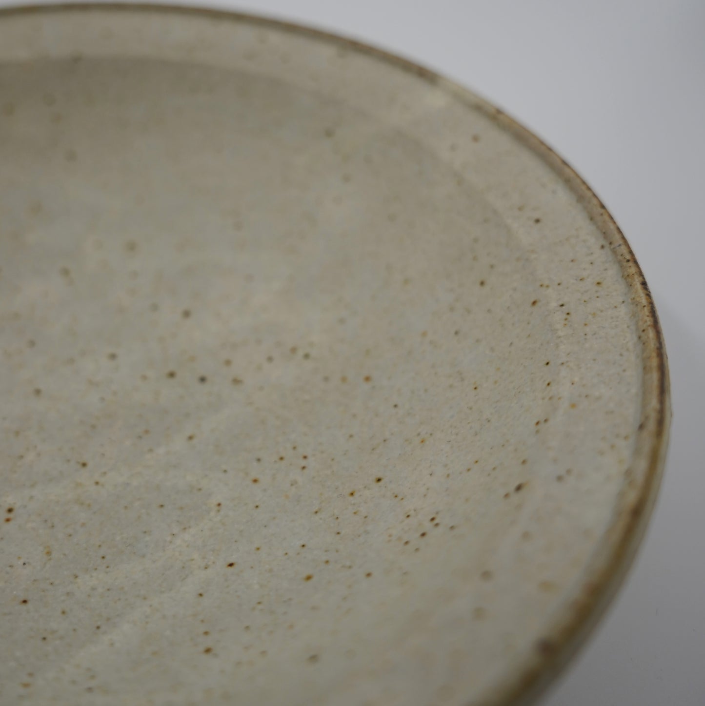 Close-up of a ceramic plate with a textured surface on a white background